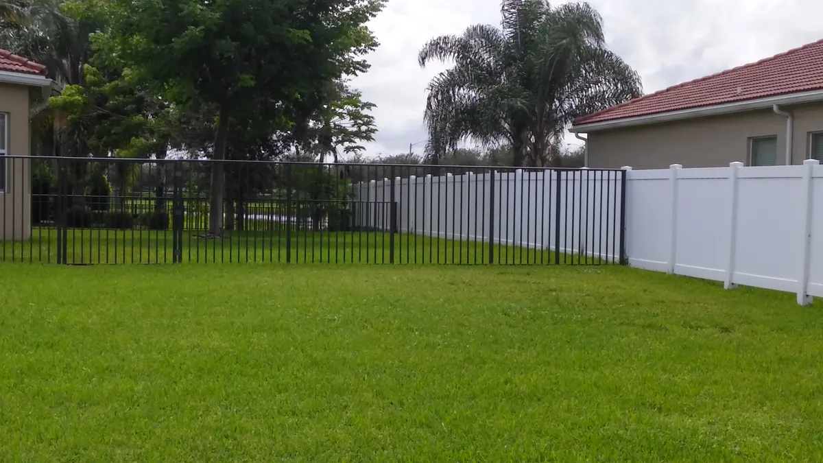 Black aluminum and white vinyl fence combination